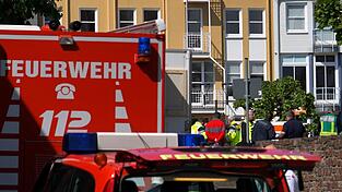 Rettungswagen, Polizisten und Polizeifahrzeuge stehen in der N&auml;he des Einsatzortes.