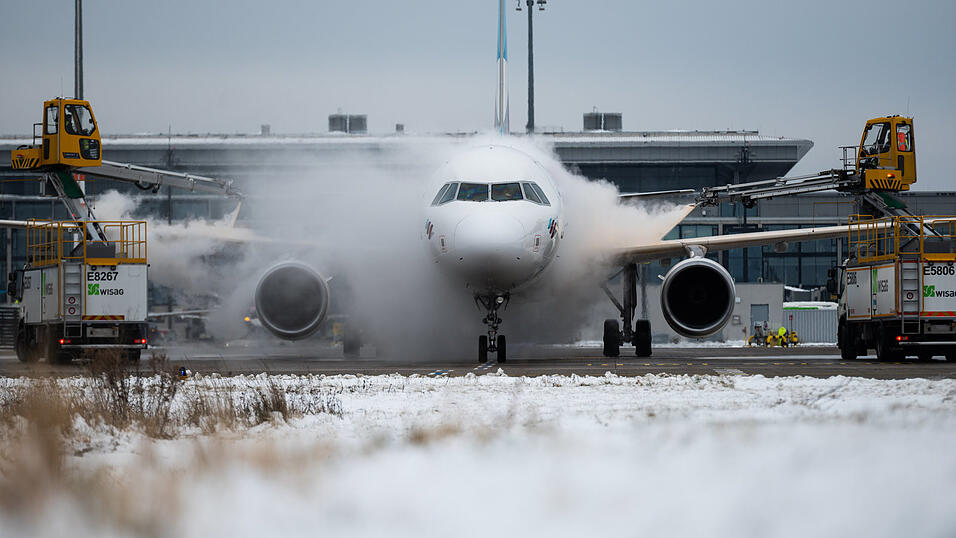 Am Flughafen Berlin-Brandenburg BER wird ein Flugzeug der Airline Eurowings auf einer Enteisungsfl&auml;che enteist.