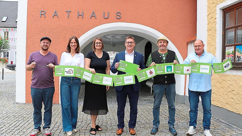Die Gr&uuml;ne-B&auml;nder-Aktion &bdquo;Wir sind Mainburg&ldquo; zum Stadtjubil&auml;um - pr&auml;sentiert von den Mitarbeitern des Stadtmarketings, Christoph Kempf, Cornelia Kroiss, Christin Grundmann-Fritz , B&uuml;rgermeister Helmut Fichtner, Musiker Ritsch Ermeier und Alexander Herzog von der Werbeagentur Imago (v. l.).