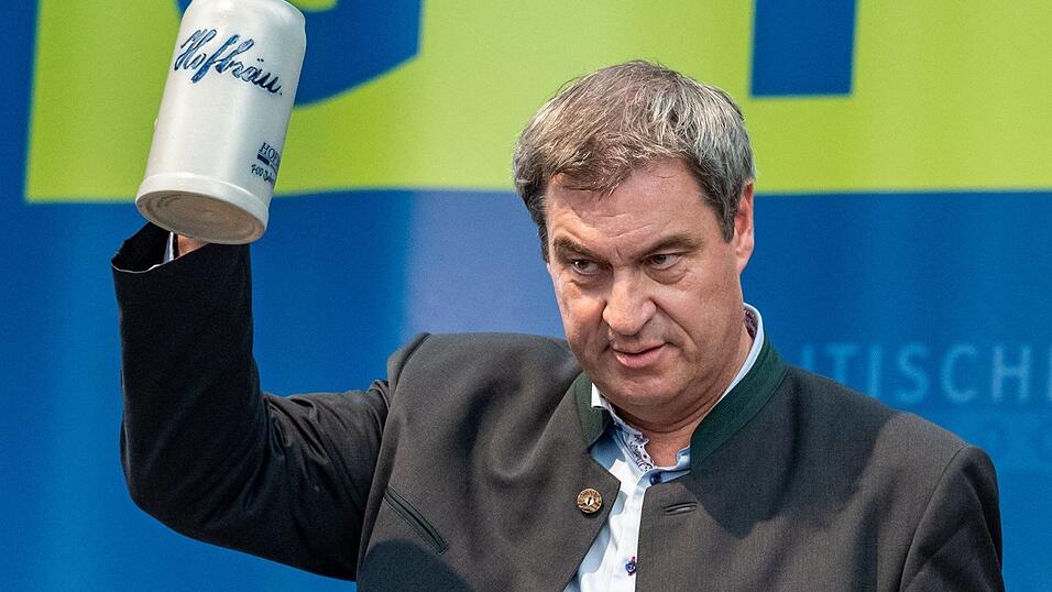 Markus Söder, Bayerns Ministerpräsident und Vorsitzender der CSU, steht beim Politischen Frühschoppen seiner Partei auf dem Volksfest Gillamoos mit einem Bierkrug auf der Bühne. Markus Söder, Bayerns Ministerpräsident und Vorsitzender der CSU, steht beim Politischen Frühschoppen seiner Partei auf dem Volksfest Gillamoos mit einem Bierkrug auf der Bühne.