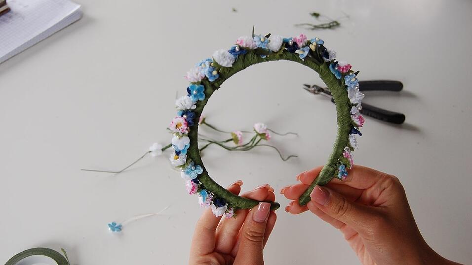 7. Wenn die erste Hälfte befestigt ist, geht's mit der zweiten weiter wie gehabt. Erst die Blümchen ineinander binden, dann mit Klebeband am Haarreif befestigen. Am Schluss noch alle Blüten schön zurechtzupfen. 7. Wenn die erste Hälfte befestigt ist, geht's mit der zweiten weiter wie gehabt. Erst die Blümchen ineinander binden, dann mit Klebeband am Haarreif befestigen. Am Schluss noch alle Blüten schön zurechtzupfen.