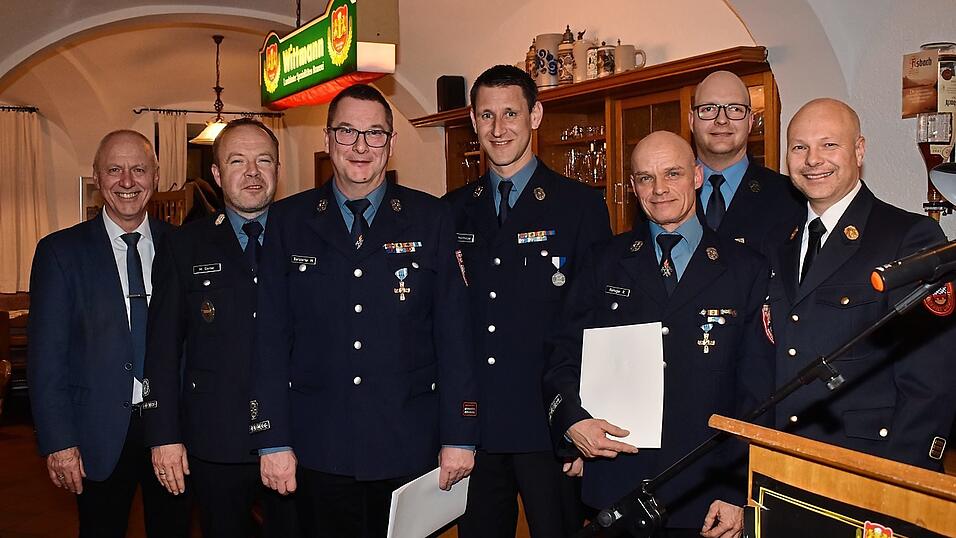 Das Ehrenkreuz in Gold erhielten Martin Barstorfer und Ralf Remiger (linkes Bild, vorne von links). Es gratulierten (dahinter von links) B&uuml;rgermeister Josef Reff, die Kommandanten Michael Stirner und Johann Hochholzer und Kreisbrandinspektor Wolfgang Metz.