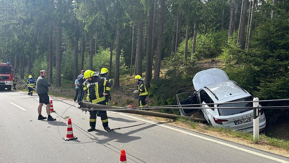 Durch den Unfall kippte der Telefonmast auf die Stra&szlig;e. Er musste von der Feuerwehr gekappt und die Leitung gesichert werden.