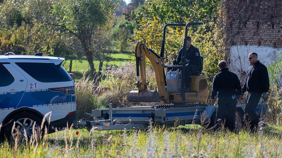 Polizisten untersuchen mit einem Bagger ein Grundstück in Herzberg (Landkreis Oder-Spree).