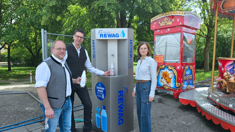 Marktleiter Stephan Pregler (v.l.), REWAG-Vorstandsvorsitzender Dr. Robert Greb und Andrea Schmid, stellvertretende Leiterin des Amts f&uuml;r &Ouml;ffentliche Ordnung und Stra&szlig;enverkehr, am Trinkwasserspender auf der Warendult.
