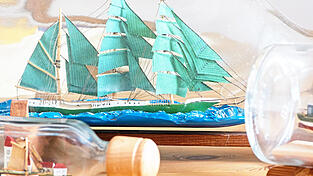 Die Flaschen mit den Buddelschiffen sind heiß begehrt, wie das Segelschiff-Modell 'Alexander von Humboldt'.