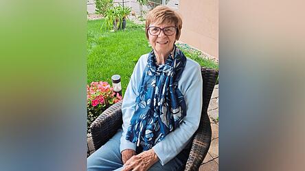 Margit Adamski sitzt auf ihrer Terasse im Garten in ihrer Erdgeschosswohnung.