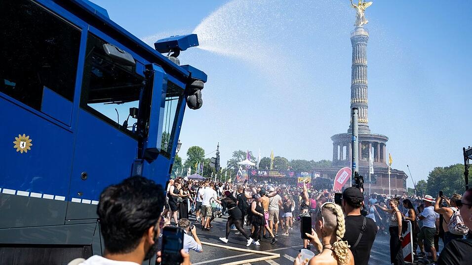 Ein Wasserwerfer der Polizei verschafft den Ravern etwas Abk&uuml;hlung.