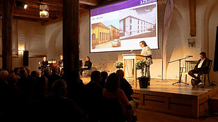 Stellvertretender Schulleiter Enno Erbe (rechts) und Schulleiter Reinhold Ostermaier (am Rednerpult) f&uuml;hrten durch eine Zeitreise der Schulgeschichte in Bildern.