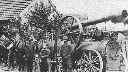 Haidlfing, Ende der 1920er Jahre: Wenn die Dampfmaschine auf den Hof kam, war das ein Ereignis, besonders für die Kinder. Um das tonnenschwere Ungetüm mit Eisenreifen, das Dampflokobil (Dampfmaschine), von Hof zu Hof zu transportieren und dort einsatzbereit zu stationieren, brauchte man Zugkraft (hier ein Gespann mit drei Pferden), einen erfahrenen Fuhrknecht und einen technisch versierten Maschinisten (hier mit Heizschaufel) zum Einrichten der Dreschgarnitur für den nächsten Einsatz. Archivfotos: Nik Söltl Haidlfing, Ende der 1920er Jahre: Wenn die Dampfmaschine auf den Hof kam, war das ein Ereignis, besonders für die Kinder. Um das tonnenschwere Ungetüm mit Eisenreifen, das Dampflokobil (Dampfmaschine), von Hof zu Hof zu transportieren und dort einsatzbereit zu stationieren, brauchte man Zugkraft (hier ein Gespann mit drei Pferden), einen erfahrenen Fuhrknecht und einen technisch versierten Maschinisten (hier mit Heizschaufel) zum Einrichten der Dreschgarnitur für den nächsten Einsatz. Archivfotos: Nik Söltl
