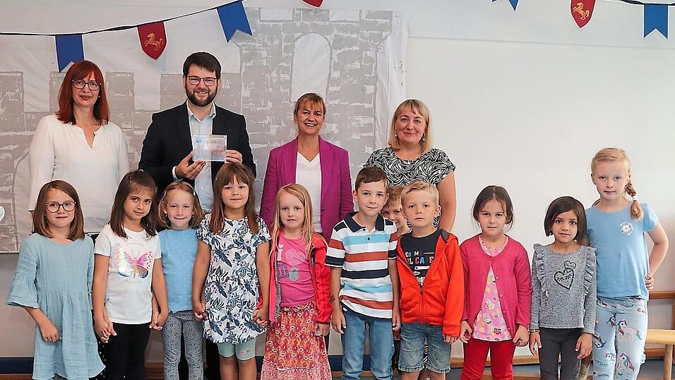 Johannes Becher mit (v. l.) Pfarrerin Regine Weller, Christiane M&uuml;nderlein (Vorst&auml;ndin Bildung und Soziales beim evKITA) und Hanna Go&szlig; (Gesamtleitung Kindergarten Weltentdecker) sowie einige der Vorschulkinder.