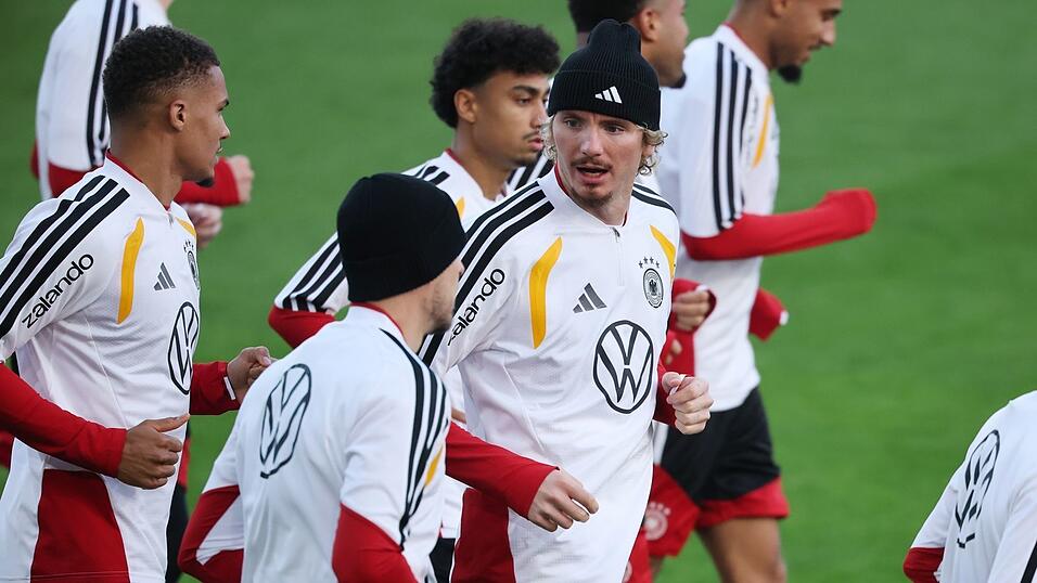Thiaw (l.) und Woltemade (mit Mütze in der Mitte) laufen beim DFB-Training.