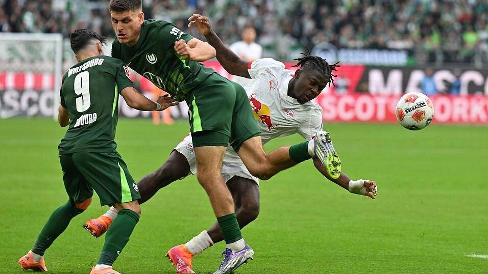 Kaum zu stoppen: Leipzigs Torschütze Johan Bakayoko (r) wird von den Wolfsburgern Joakim Maehle und Mohammed Amoura bedrängt. Kaum zu stoppen: Leipzigs Torschütze Johan Bakayoko (r) wird von den Wolfsburgern Joakim Maehle und Mohammed Amoura bedrängt.