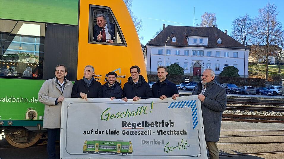 B&uuml;rgermeister Franz Wittmann (vl.l), Regens Landrat Ronny Raith, L&auml;nderbahn- Gesch&auml;ftsf&uuml;hrer Eugen Rubinstein. MdL Stefan Ebner (CSU), MdL Toni Schuberl (Gr&uuml;ne), Wolfgang Schl&uuml;ter (Go-Vit) und im Fenster des Waldbahn-Shuttles Verkehrsminister Christian Bernreiter.