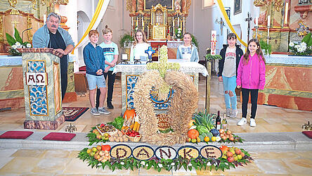 Die Minis und Mesner Joe Schweiger schauten sich nach dem Gottesdienst den sch&ouml;nen Erntealtar ganz genau an.