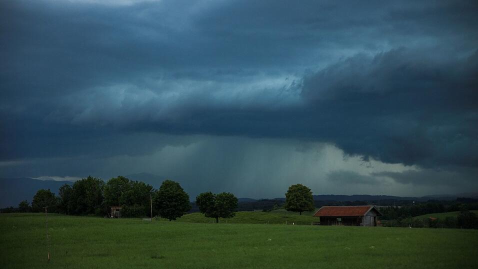 Dunkle Gewitterwolken hängen über der Landschaft in Penzberg in Oberbayern. Dunkle Gewitterwolken hängen über der Landschaft in Penzberg in Oberbayern.