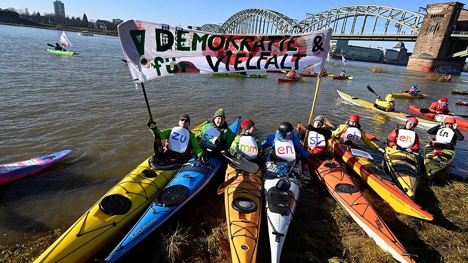 In Köln demonstrieren Wassersportler auf dem Rhein.