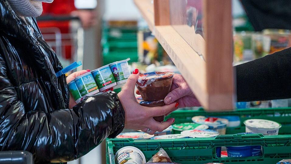 Eine Kundin (l) der Tafel Coburg bekommt Joghurt und Pudding. Der Landesverband Tafel Bayern e. V. besteht aus insgesamt 171 Mitgliedstafeln. (Archivbild)