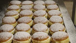 Im letzten Schritt werden die ausgek&uuml;hlten Geb&auml;ckst&uuml;cke gleichm&auml;&szlig;ig gepudert.