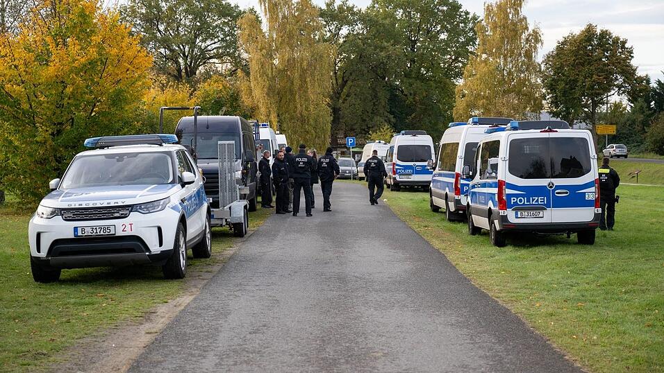 Polizeiautos stehen auf einer Wiese in Tauche.