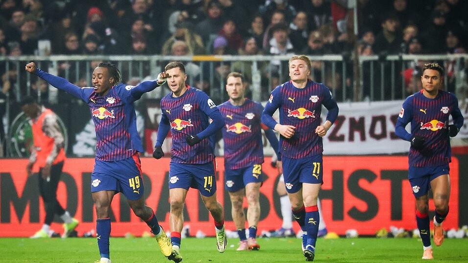 Leipzigs Yan Diomande (l,) jubelt nach seinem Treffer beim FC St. Pauli.