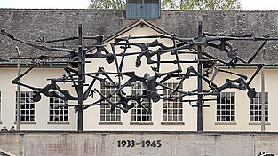 Die Bronzeskulptur 'Menschen im Stacheldraht' steht auf dem Apellplatz des früheren Konzenzrationslagers in Dachau.