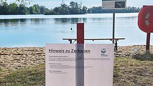 Am Sarchinger Weiher hat der Naherholungsverein Hinweisschilder aufgestellt. Im Hintergrund zieht ein Schwimmer seine Runden. Er hat keine Angst vor Zerkarien. Seine Devise: „Nach dem Schwimmen gut abtrocknen.“ Am Sarchinger Weiher hat der Naherholungsverein Hinweisschilder aufgestellt. Im Hintergrund zieht ein Schwimmer seine Runden. Er hat keine Angst vor Zerkarien. Seine Devise: „Nach dem Schwimmen gut abtrocknen.“
