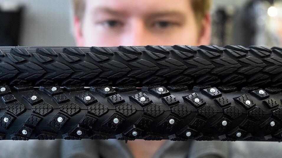 Ein Winterreifen mit Spikes (l) und ein Radreifen für Tourenfahrten (r) werden am 11.01.2016 in einem Fachgeschäft für Zweiräder in Langenhagen in der Region Hannover (Niedersachsen) präsentiert. Ein Winterreifen mit Spikes (l) und ein Radreifen für Tourenfahrten (r) werden am 11.01.2016 in einem Fachgeschäft für Zweiräder in Langenhagen in der Region Hannover (Niedersachsen) präsentiert.