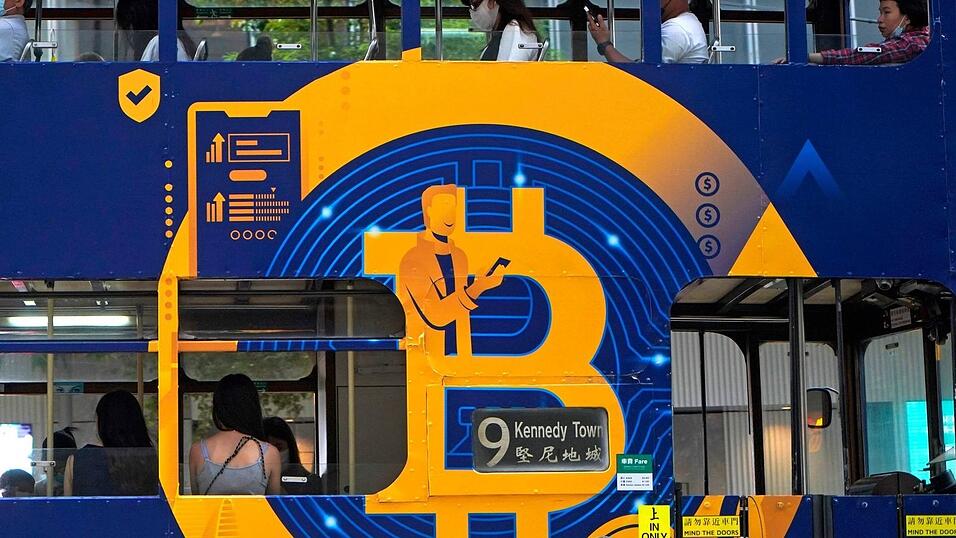 Eine Werbung für die Kryptowährung Bitcoin auf einer Hongkonger Straßenbahn. Kryptoanleger weltweit glauben laut einer Umfrage, dass es weiter aufwärts geht. (Foto: Illustration)