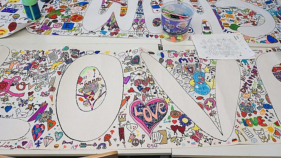 In schreiend bunten Farben pr&auml;sentieren sich die ersten Teile der gro&szlig;en Wimmelbilder, die die Sch&uuml;ler f&uuml;r das Stra&szlig;enkunstfestival anfertigen. Dieses Bild zieren Motive rund um das Thema Liebe.