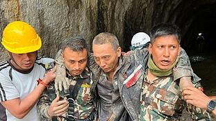 Rettungskräfte tragen einen Überlebenden der Sturzflutkatastrophe in Nepal. Rettungskräfte tragen einen Überlebenden der Sturzflutkatastrophe in Nepal.