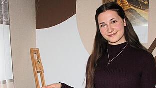 Veronika präsentiert ein Gemälde vom Schulberg, das sie gemalt hat.