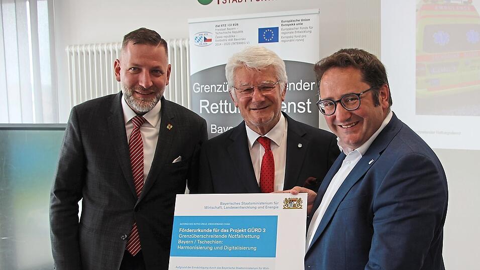 Im BRK-Rettungszentrum &uuml;bergibt der Wirtschaftsstaatssekret&auml;r Tobias Gotthardt (rechts) die F&ouml;rderurkunde an den BRK-Kreisvorsitzenden Theo Zellner und Pilsens Regionalpr&auml;sidenten Rudolf &Scaron;pot&aacute;k (links)
