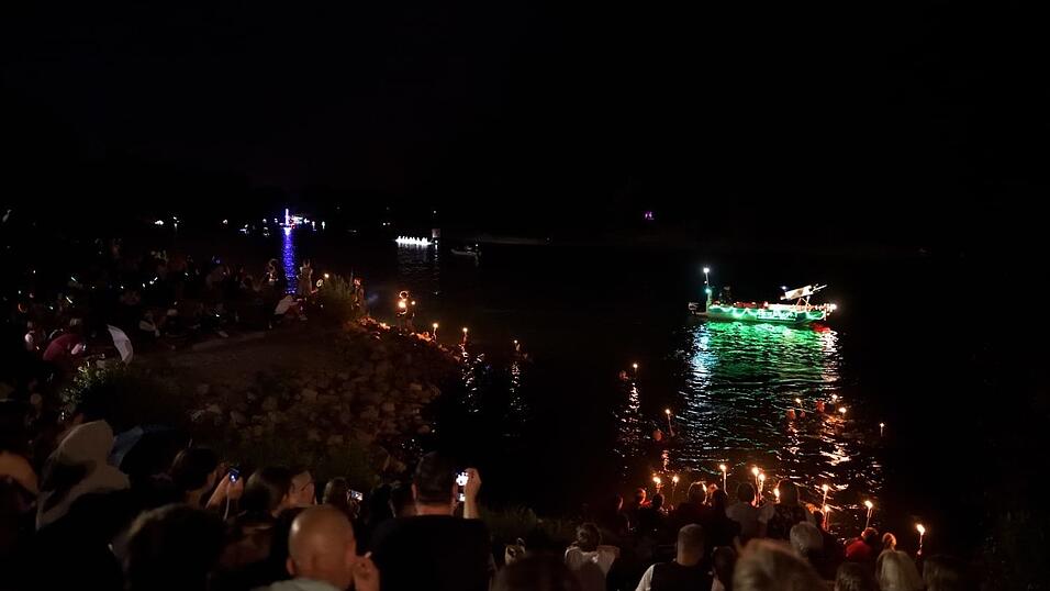 Bunt beleuchtete Boote fahren bei der Lampionfahrt über die Donau.
