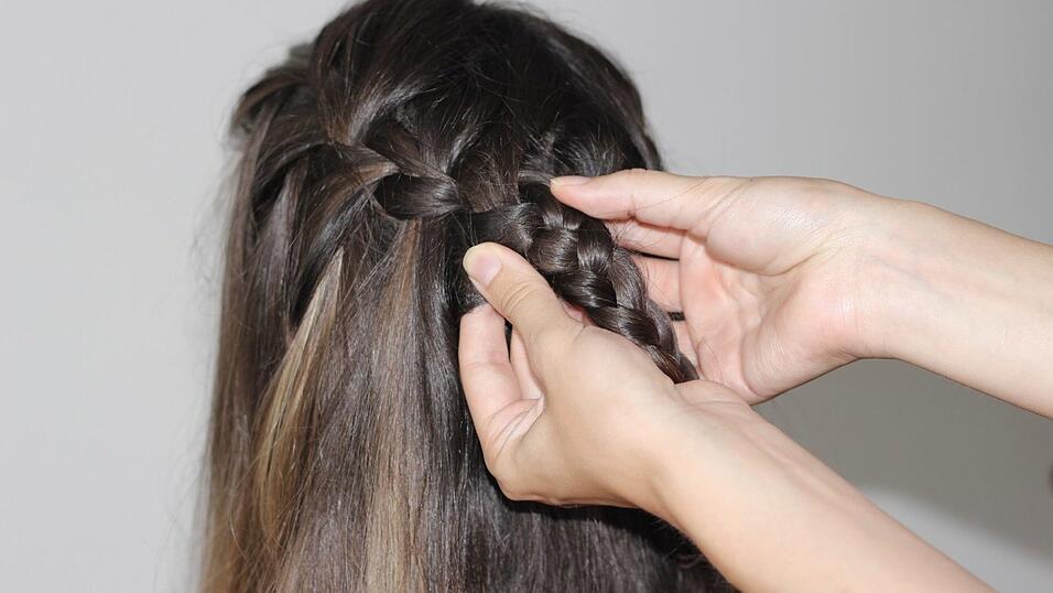 Um die Flechtfrisur etwas aufzulockern, zieht man die beiden Zöpfe vorsichtig etwas auseinander. Um die Flechtfrisur etwas aufzulockern, zieht man die beiden Zöpfe vorsichtig etwas auseinander.