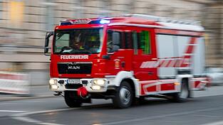 Ein Feuerwehrfahrzeug ist mit Blaulicht auf Einsatzfahrt.