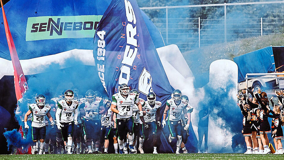 Unter blauem Rauch stürmen die Spieler der Straubing Spiders in die neue GFL-Saison.