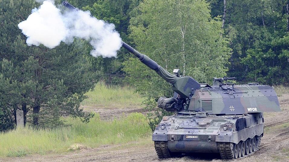 Eine Panzerhaubitze 2000 der Bundeswehr feuert bei einer Fahrt auf dem Truppenübungsplatz.