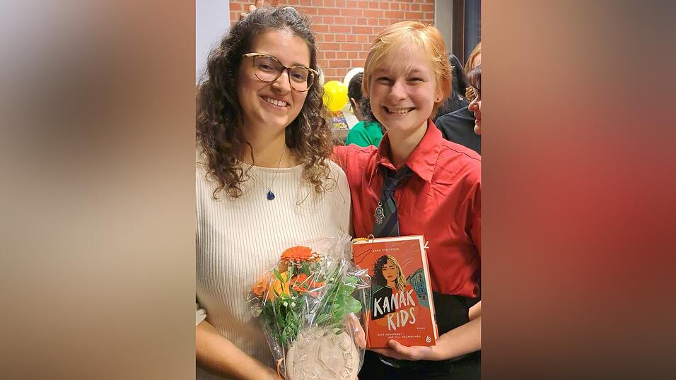 Anna Dimitrova, die Autorin von „Kanak Kids“, zusammen mit Alexander Kraitschik, einem Mitglied des Jugendleseclubs der Stadtbücherei Landshut, bei der Bekanntgabe der Gewinnerbücher
