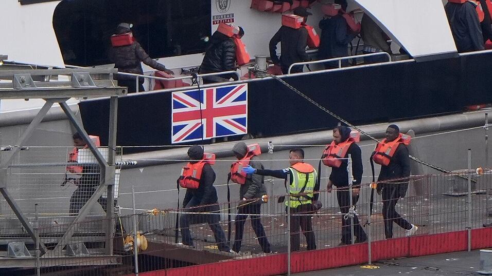 Eine Gruppe von Menschen, bei denen es sich vermutlich um Migranten handelt, wird im Juli 2025 nach einem Zwischenfall mit einem kleinen Boot im Ärmelkanal von einem Schiff der Border Force nach Dover, Kent, gebracht. Eine Gruppe von Menschen, bei denen es sich vermutlich um Migranten handelt, wird im Juli 2025 nach einem Zwischenfall mit einem kleinen Boot im Ärmelkanal von einem Schiff der Border Force nach Dover, Kent, gebracht.
