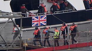 Eine Gruppe von Menschen, bei denen es sich vermutlich um Migranten handelt, wird im Juli 2025 nach einem Zwischenfall mit einem kleinen Boot im Ärmelkanal von einem Schiff der Border Force nach Dover, Kent, gebracht. Eine Gruppe von Menschen, bei denen es sich vermutlich um Migranten handelt, wird im Juli 2025 nach einem Zwischenfall mit einem kleinen Boot im Ärmelkanal von einem Schiff der Border Force nach Dover, Kent, gebracht.