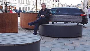 Vor der L&ouml;wen-Apotheke ist die Sitzbankgruppe kleiner geworden. Das Auto, von dem links ein Teil zu sehen ist, steht auf einem der drei neuen Stellpl&auml;tze.