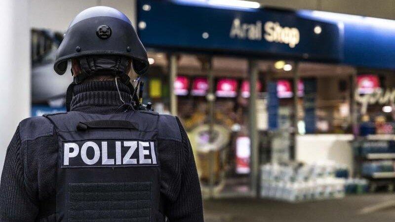 Ein Polizist steht vor der Tankstelle, an der ein Angestellter von einem Mann erschossen worden ist.