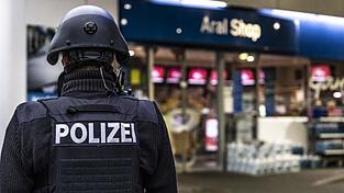 Ein Polizist steht vor der Tankstelle, an der ein Angestellter von einem Mann erschossen worden ist. Ein Polizist steht vor der Tankstelle, an der ein Angestellter von einem Mann erschossen worden ist.