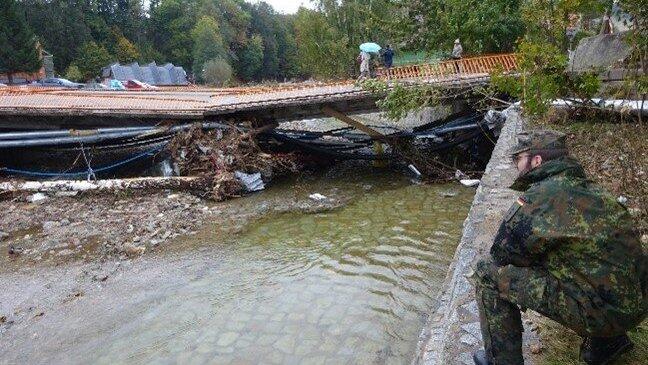 Zerstörte Brücke über die Biala Ladecka (Biele) im Zentrum von Stronie Slaskie (Seitenberg): Hauptmann Kevin B. nimmt die Brückenfundamente in Augenschein. Zerstörte Brücke über die Biala Ladecka (Biele) im Zentrum von Stronie Slaskie (Seitenberg): Hauptmann Kevin B. nimmt die Brückenfundamente in Augenschein.