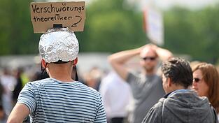 Ein Mann mit Aluhut bei einer Demonstration gegen die Corona-Beschränkungen. Kritiker befürchten, dass Verschwörungstheoretiker und Rechtspopulisten die Proteste vereinnahmen. Ein Mann mit Aluhut bei einer Demonstration gegen die Corona-Beschränkungen. Kritiker befürchten, dass Verschwörungstheoretiker und Rechtspopulisten die Proteste vereinnahmen.