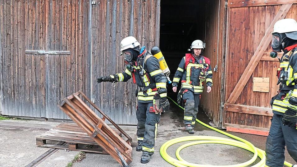 Atemschutztr&auml;ger bef&ouml;rderten die Holzpaletten ins Freie.