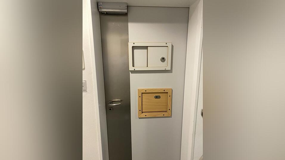 Eine Tür zu einem Patienten-Zimmer. Türen sind links mit Stahl gesichert. Es gibt eine Sicht- und eine Kostklappe. Üblicherweise ist offen, Patienten können sich innerhalb der Station frei bewegen. Eine Tür zu einem Patienten-Zimmer. Türen sind links mit Stahl gesichert. Es gibt eine Sicht- und eine Kostklappe. Üblicherweise ist offen, Patienten können sich innerhalb der Station frei bewegen.