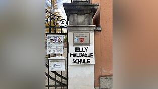 Regensburger Linke haben am Mittwoch ein Schild mit dem Namen „Elly Maldaque Schule“ am Eingang der Von-der-Tann-Schule angebracht.