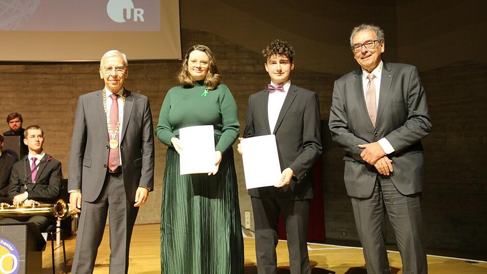 Udo Hebel (links) und Peter Küspert (rechts) überreichten den Preis für studentisches Engagement an Madeleine Schneider und Tim Oberding.